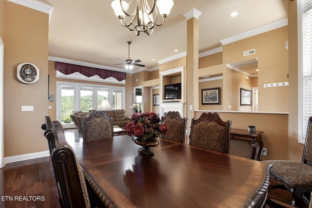 dining area featuring ornamental molding, dark wood-type flooring, and ceiling fan with notable chandelier