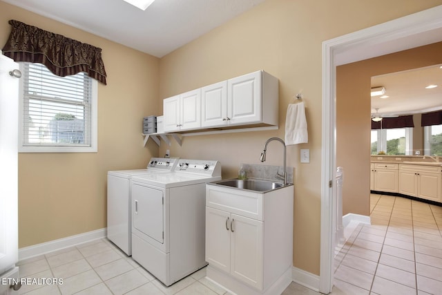 laundry room with cabinets, light tile patterned flooring, sink, and independent washer and dryer