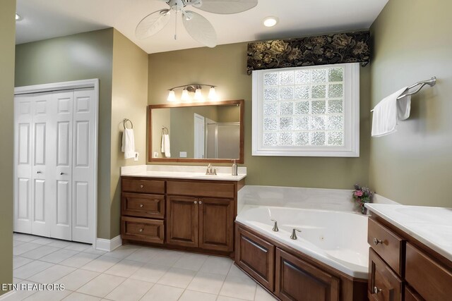 bathroom featuring ceiling fan, tile patterned floors, vanity, and plus walk in shower