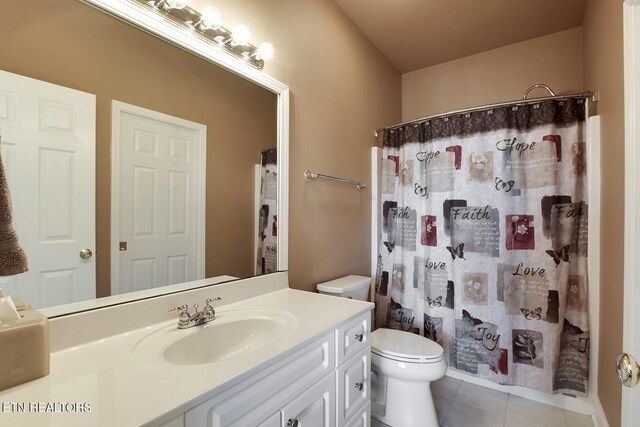 bathroom featuring vanity, tile patterned floors, and toilet