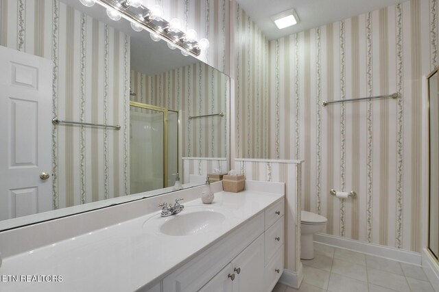 bathroom featuring vanity, toilet, an enclosed shower, and tile patterned flooring