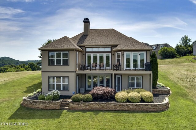 rear view of property featuring a yard and french doors