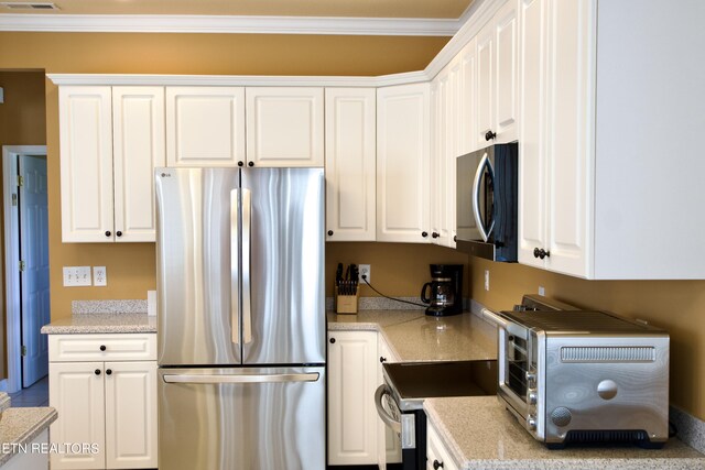 kitchen with stainless steel appliances, crown molding, and white cabinets