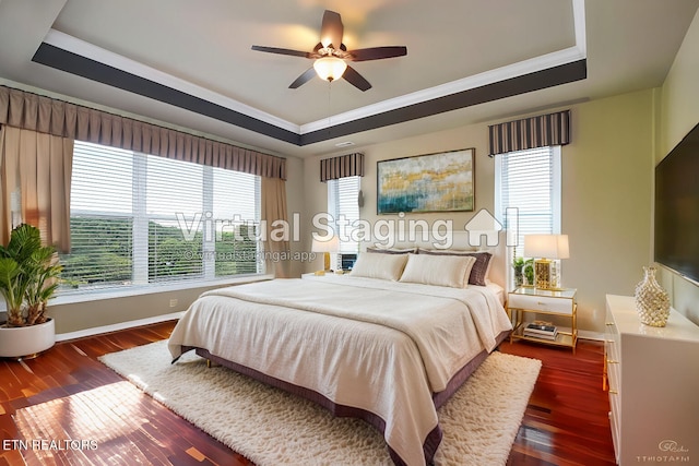 bedroom with crown molding, dark wood-type flooring, and a tray ceiling