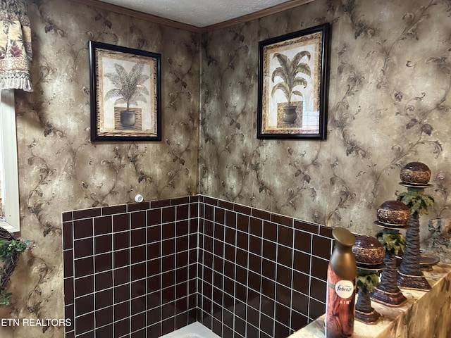 bathroom with a textured ceiling and crown molding