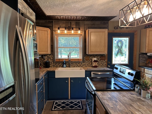 kitchen featuring decorative light fixtures, sink, stainless steel appliances, and plenty of natural light