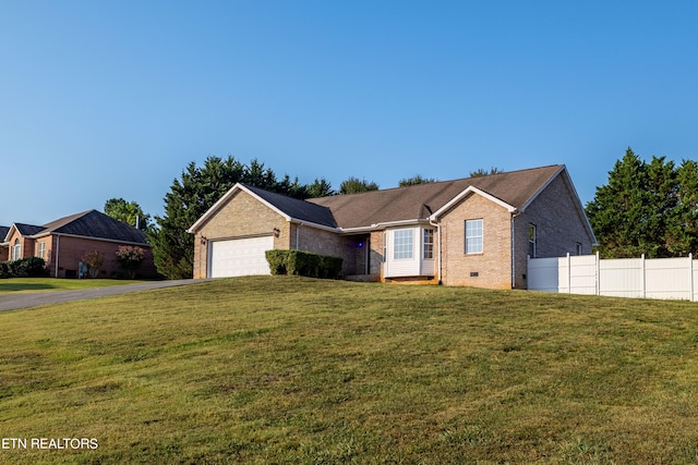 ranch-style house with a garage and a front lawn