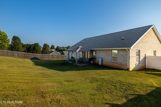 rear view of house with a lawn, a patio, and a gazebo