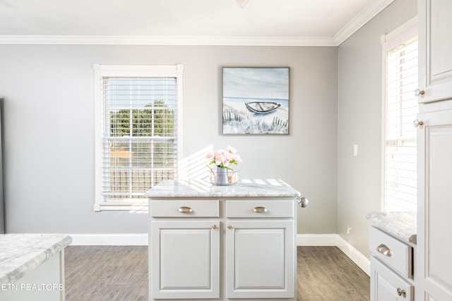 kitchen with light wood-type flooring, ornamental molding, and a wealth of natural light