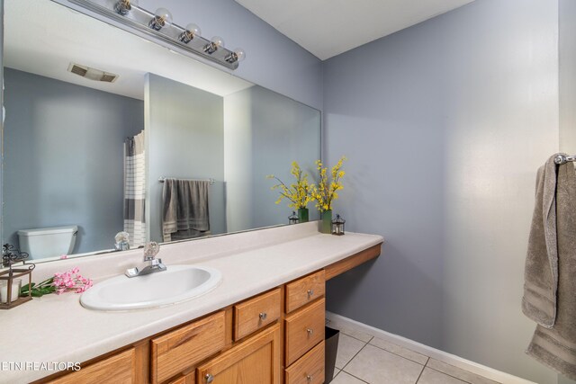 bathroom with vanity, toilet, and tile patterned floors