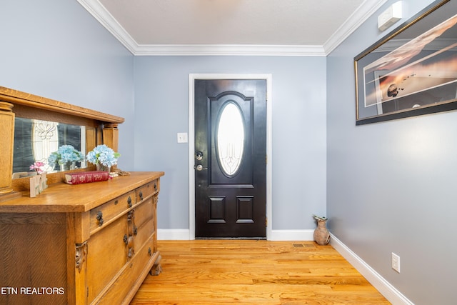 entryway featuring ornamental molding and light hardwood / wood-style flooring