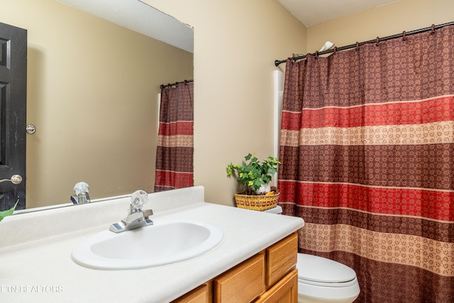 bathroom featuring vanity, toilet, and walk in shower