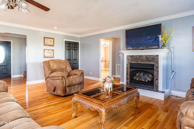 living room featuring light wood-type flooring, ceiling fan, and ornamental molding