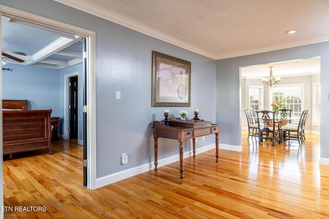 hall with coffered ceiling, ornamental molding, light hardwood / wood-style floors, and beam ceiling