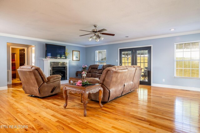 living room with crown molding, ceiling fan, and light hardwood / wood-style floors