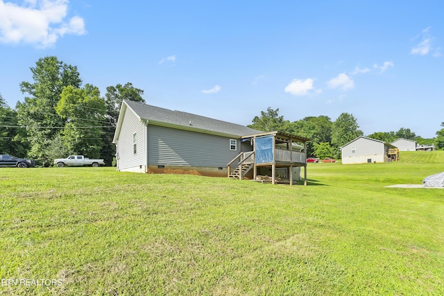 rear view of property featuring a yard and a wooden deck