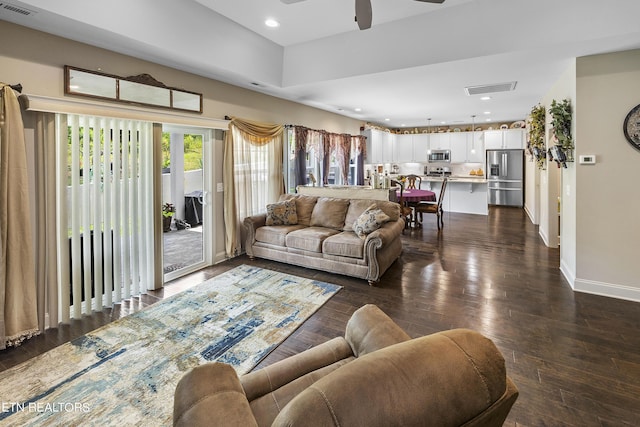 living room featuring ceiling fan and dark hardwood / wood-style flooring