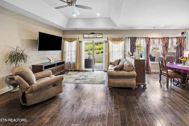 living room with ceiling fan, hardwood / wood-style flooring, and a tray ceiling