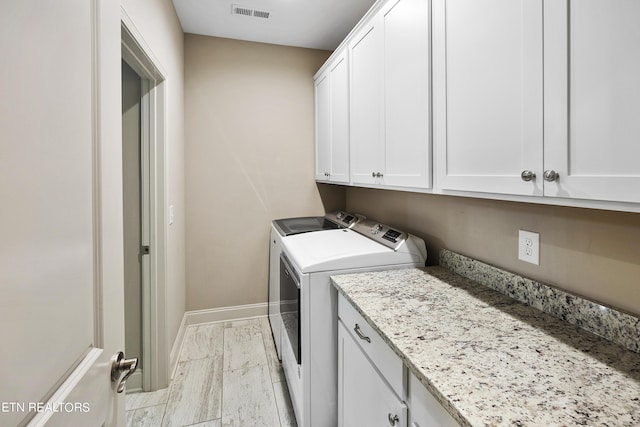 laundry room featuring cabinets and washer and clothes dryer