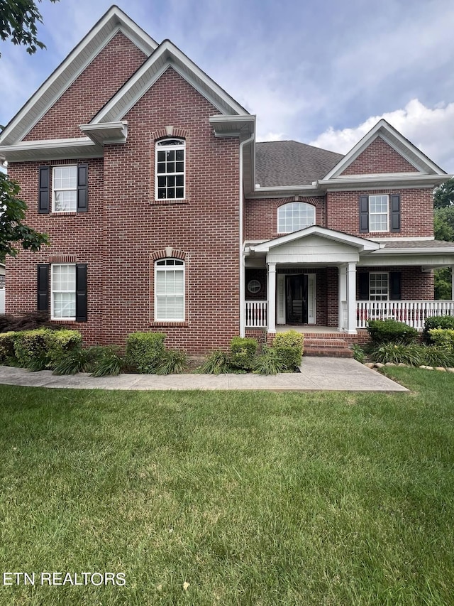 view of front of home featuring a porch and a front lawn