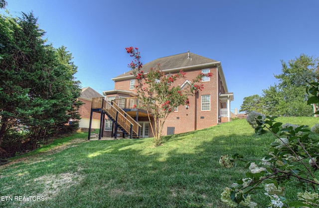 back of house with a deck and a lawn