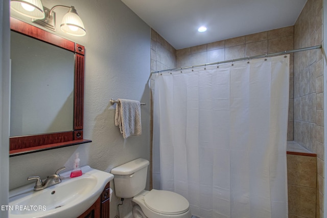 bathroom with vanity, toilet, and curtained shower