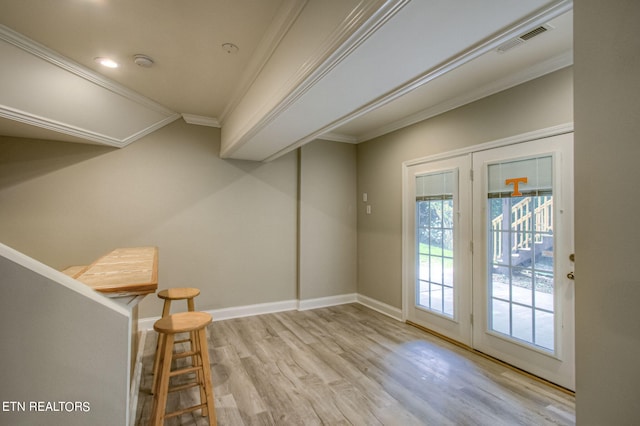 entryway featuring ornamental molding and light hardwood / wood-style floors