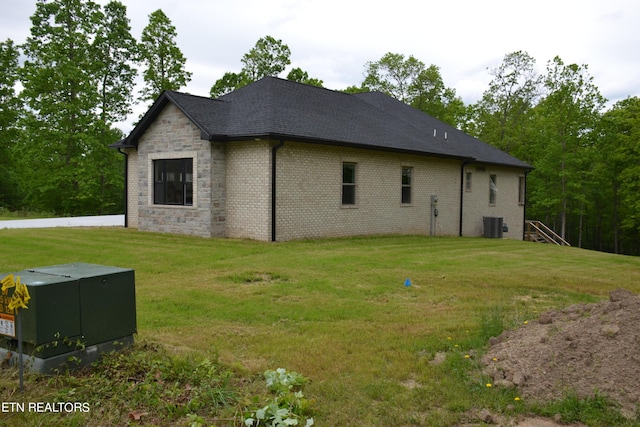 view of home's exterior with a lawn and central air condition unit