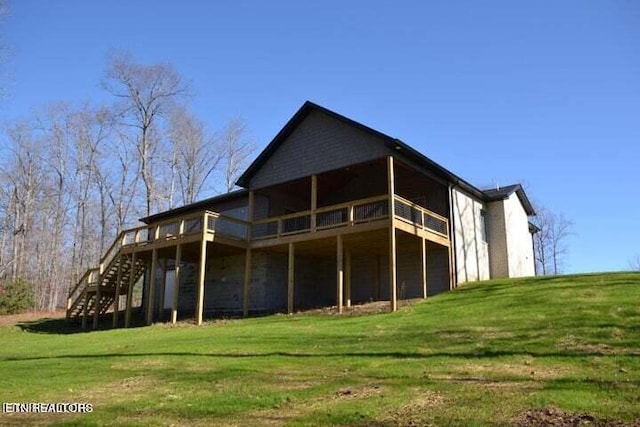 back of property with a deck and a yard