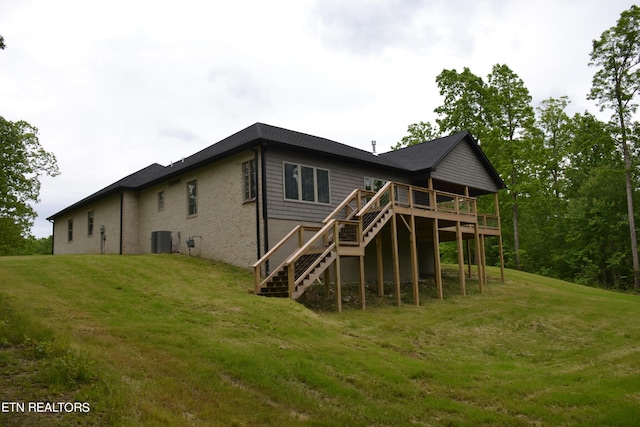 back of property featuring a yard, central AC unit, and a wooden deck