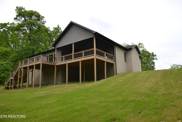 rear view of property featuring a yard and a deck