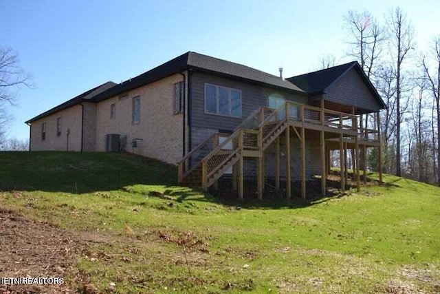 back of property featuring a wooden deck and a yard