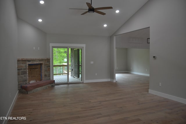 unfurnished living room featuring a fireplace, ceiling fan, hardwood / wood-style floors, and high vaulted ceiling