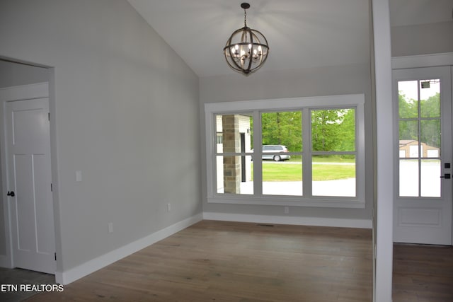 entrance foyer with dark hardwood / wood-style floors, vaulted ceiling, and a notable chandelier