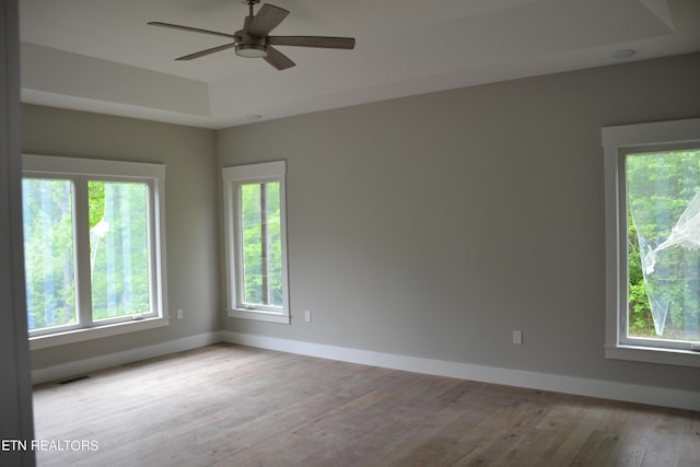 spare room with light hardwood / wood-style floors, ceiling fan, and a healthy amount of sunlight