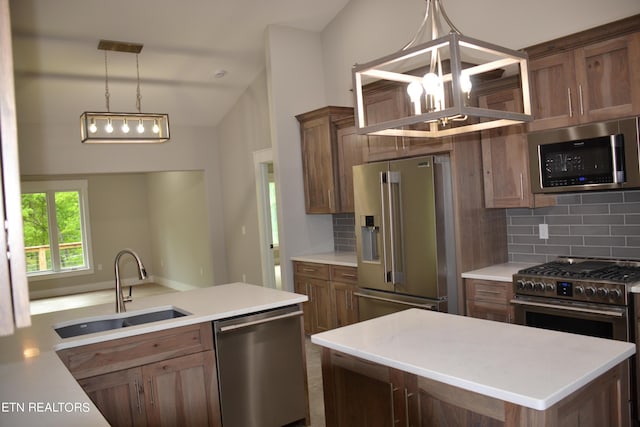 kitchen with decorative backsplash, high quality appliances, sink, and hanging light fixtures