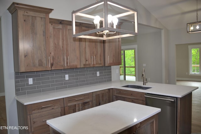 kitchen with stainless steel dishwasher, lofted ceiling, sink, and tasteful backsplash