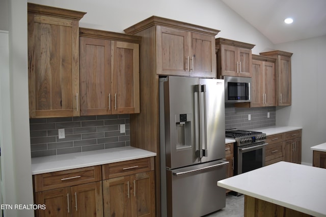 kitchen with decorative backsplash, stainless steel appliances, and vaulted ceiling