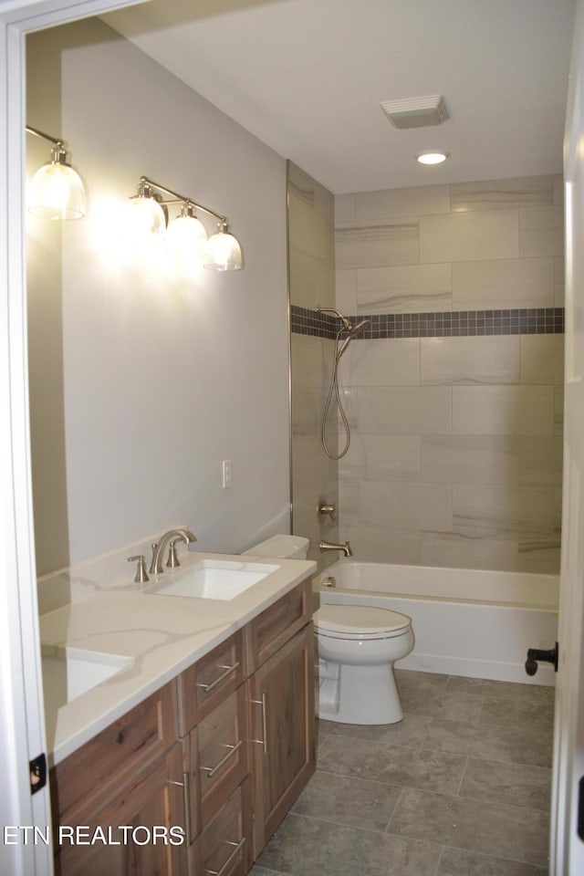 full bathroom with vanity, toilet, and tiled shower / bath combo