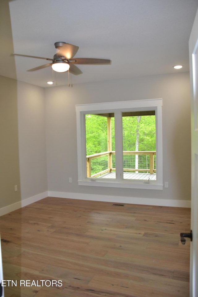 unfurnished room with ceiling fan and wood-type flooring