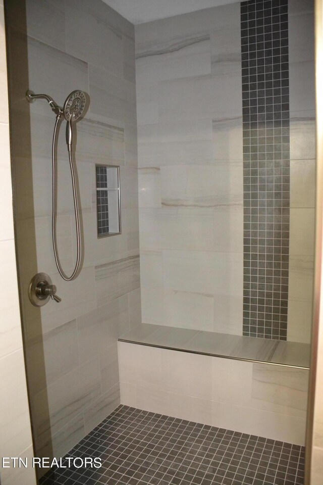 bathroom with tile patterned floors and a tile shower