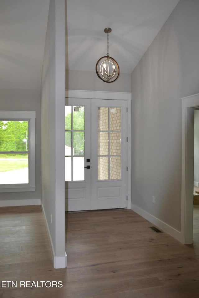 entryway featuring hardwood / wood-style floors, an inviting chandelier, and french doors