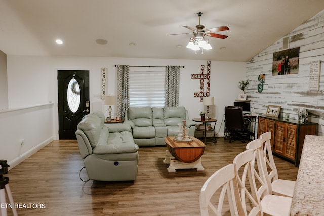 living room featuring wood-type flooring, lofted ceiling, and ceiling fan