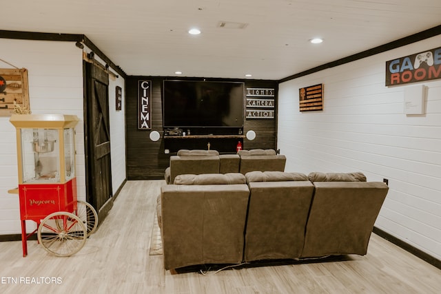 living room featuring a barn door and light hardwood / wood-style flooring