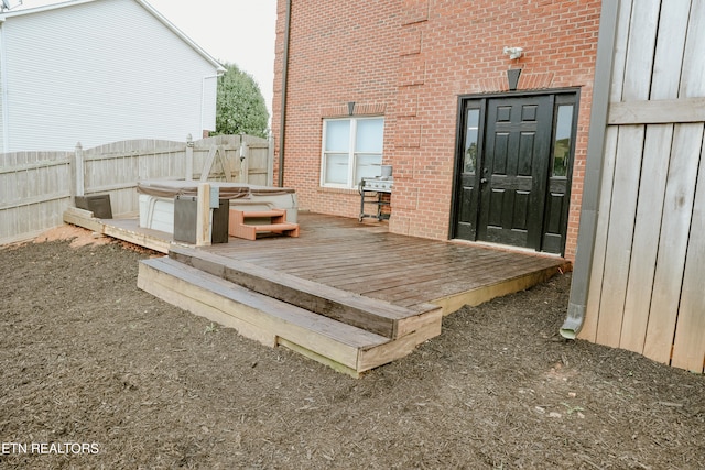 wooden deck with a hot tub