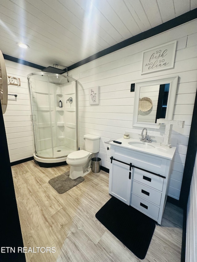 bathroom featuring hardwood / wood-style floors, vanity, wood ceiling, toilet, and a shower with door