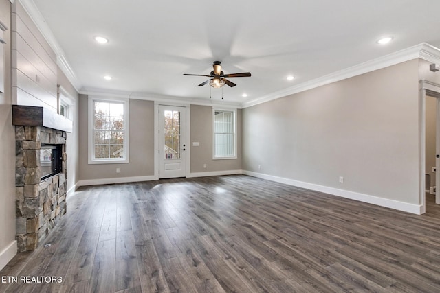 unfurnished living room with ceiling fan, a stone fireplace, dark hardwood / wood-style flooring, and ornamental molding