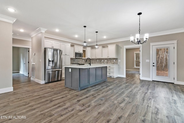 kitchen with white cabinetry, hardwood / wood-style floors, appliances with stainless steel finishes, and decorative light fixtures