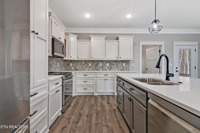 kitchen featuring stainless steel appliances, pendant lighting, sink, dark hardwood / wood-style floors, and white cabinetry