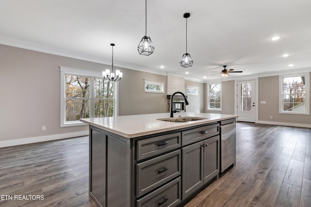 kitchen with ornamental molding, decorative light fixtures, dark hardwood / wood-style floors, sink, and a kitchen island with sink